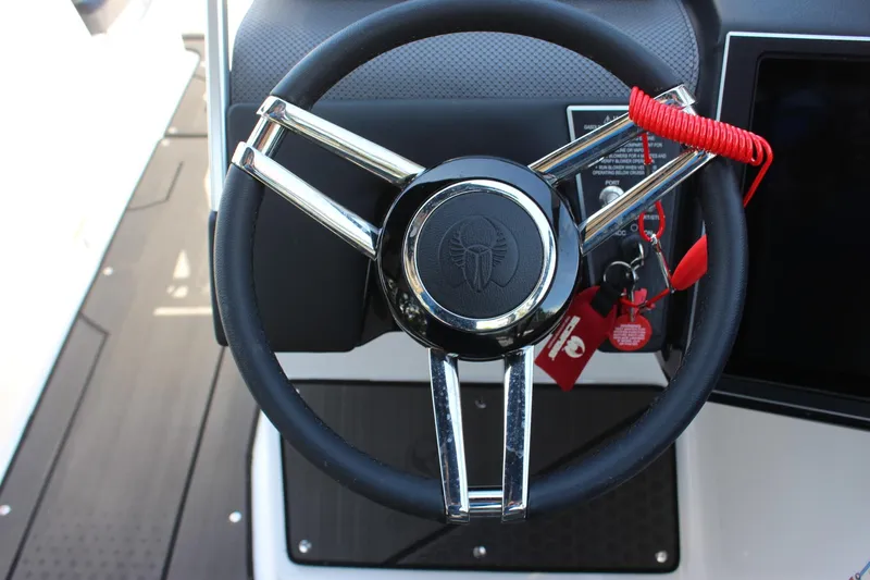 Slide: The Image of Steering wheel of 2023 Scarab 285 ID boat with red safety lanyard. - 13