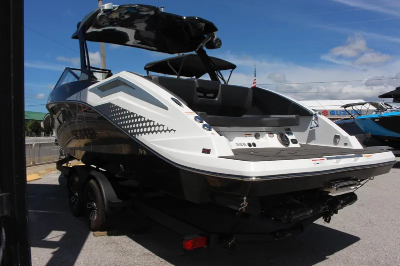 Slide: The Image of 2023 Scarab 285 ID boat, rear view, on a trailer, under a clear sky. - 2