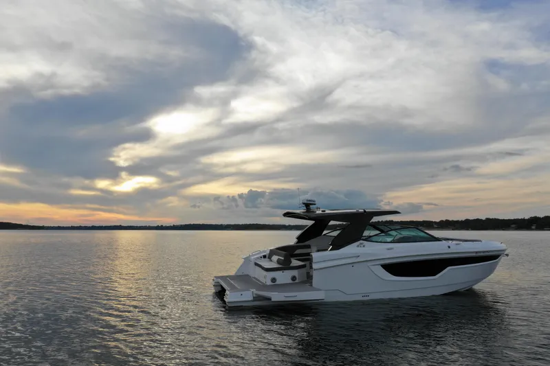 The Image of 2022 Cruisers Yachts 38 GLS on serene water at sunset. - 0