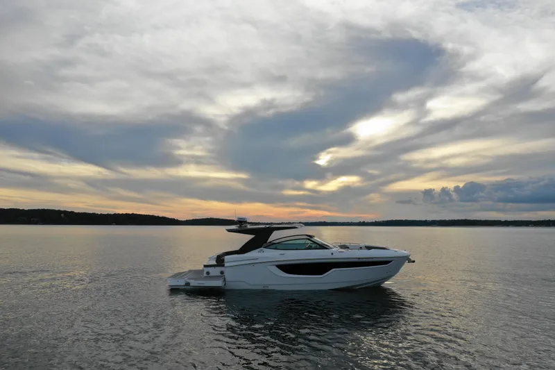 Slide: The Image of 2022 Cruisers Yachts 38 GLS on calm water at sunset. - 2