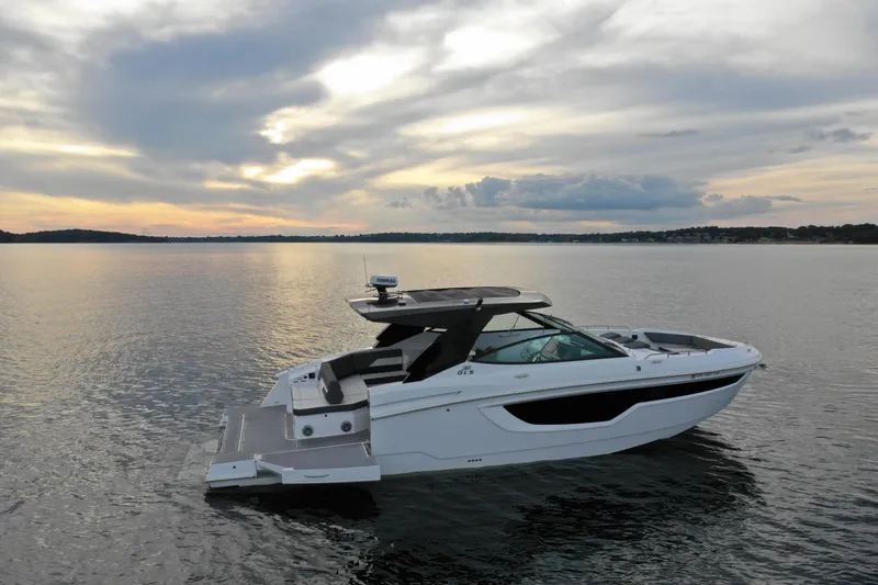 Slide: The Image of 2022 Cruisers Yachts 38 GLS on serene water at sunset. - 4