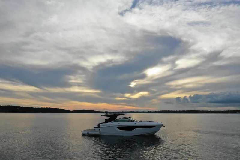 Slide: The Image of 2022 Cruisers Yachts 38 GLS on serene water at sunset. - 7