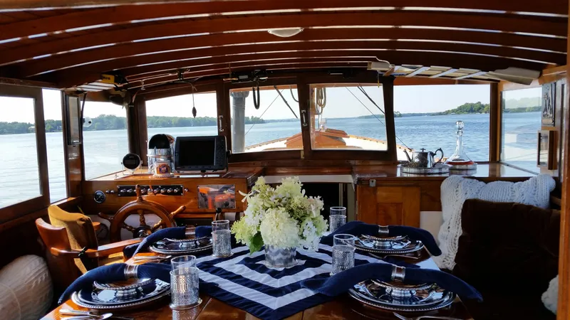 Slide: The Image of Interior of 1930 Blanchard Lake Union Dreamboat with elegant dining setup and scenic water view. - 14
