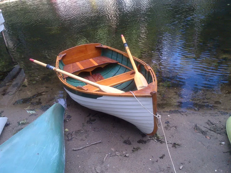 Slide: The Image of Vintage 1930 Blanchard Lake Union Dreamboat with oars on a sandy shore. - 23