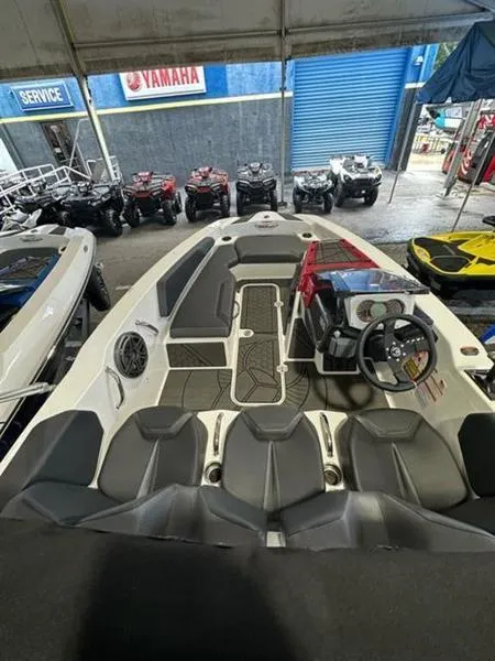 Slide: The Image of 2023 Scarab 165 ID boat interior at dealership with ATVs in background. - 5