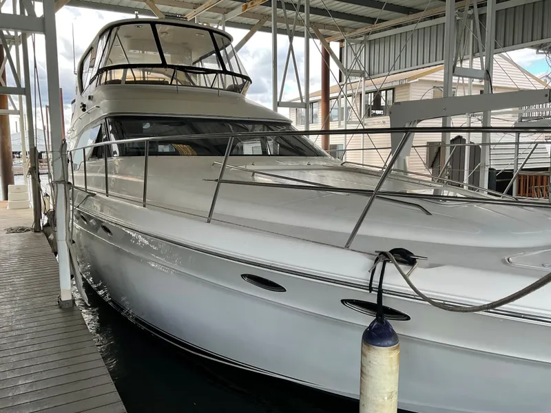 Slide: The Image of 1999 Sea Ray 560 Sedan Bridge yacht docked in a covered marina. - 1