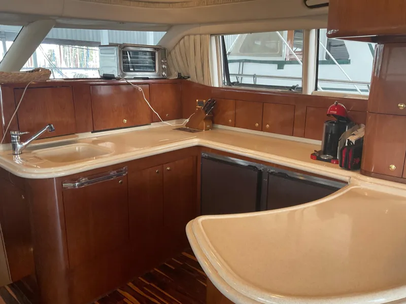 Slide: The Image of Luxurious kitchen interior of 1999 Sea Ray 560 Sedan Bridge yacht with wooden cabinetry. - 10