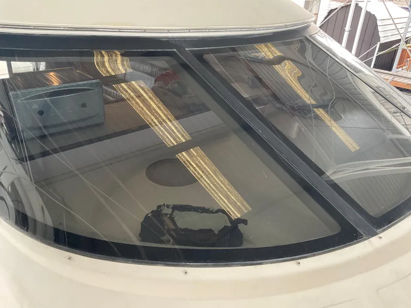 Slide: The Image of 1999 Sea Ray 560 Sedan Bridge yacht with reflective windows in a marina setting. - 2