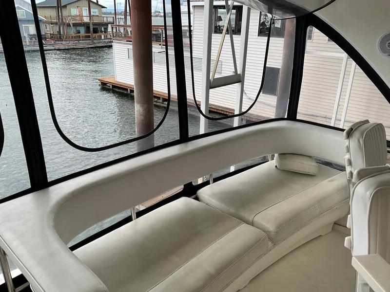 Slide: The Image of 1999 Sea Ray 560 Sedan Bridge interior with white seating and waterfront view. - 21