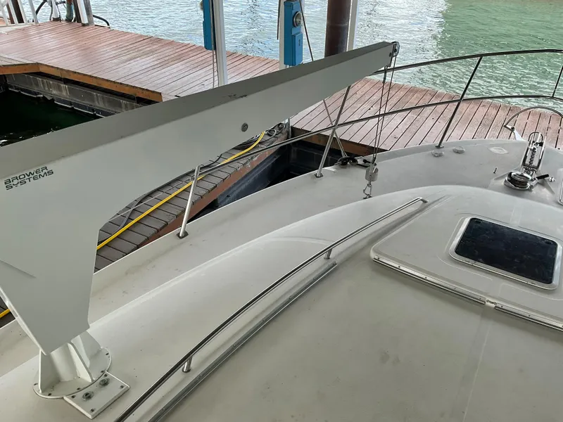 Slide: The Image of 1999 Sea Ray 560 Sedan Bridge yacht deck with davit system, docked by the water. - 22