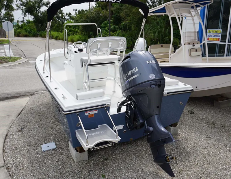 Slide: The Image of 2024 Parker 1801 CS boat with Yamaha 115 outboard motor, docked on gravel. - 10