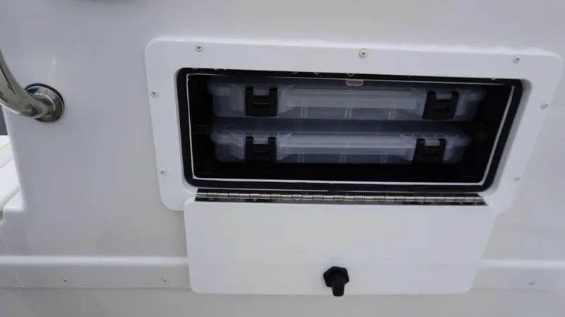 Slide: The Image of Storage compartment on a 2024 Parker 1801 CS boat with two plastic containers. - 8