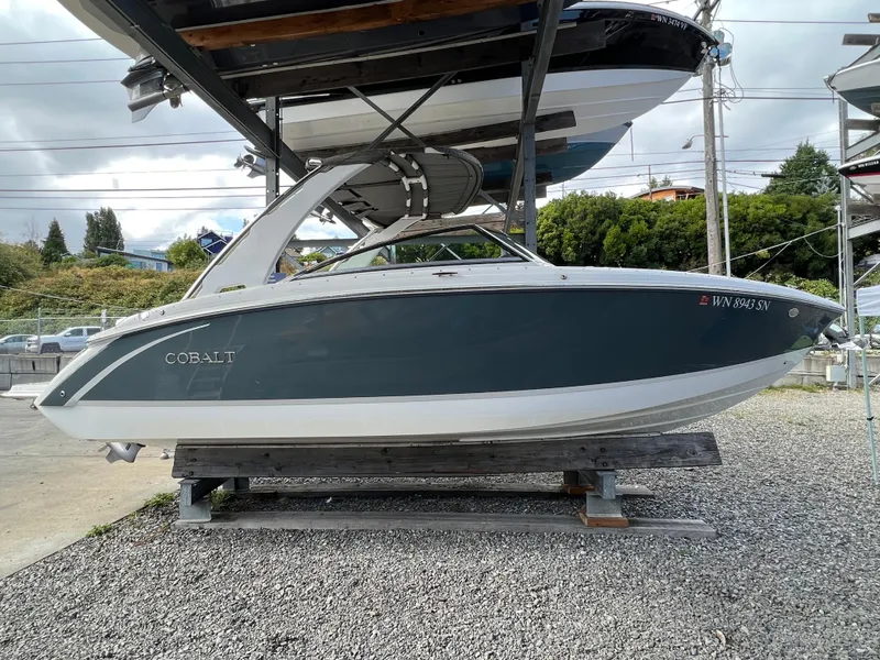 Slide: The Image of 2018 Cobalt R5 boat on display, side view, in a marina setting. - 24