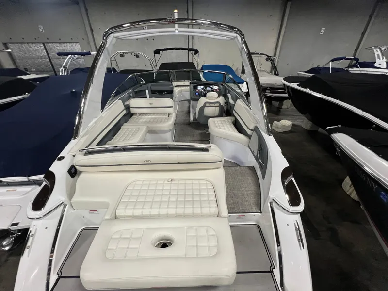Slide: The Image of 2018 Cobalt R5 boat interior with white seating and modern dashboard in a showroom. - 6