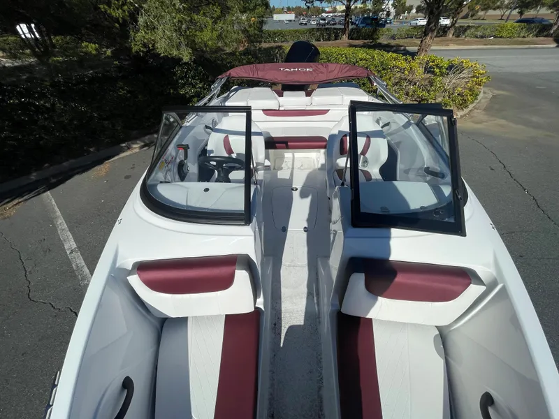 Slide: The Image of 2024 Tahoe 185 S boat with red and white interior, docked in a marina. - 3