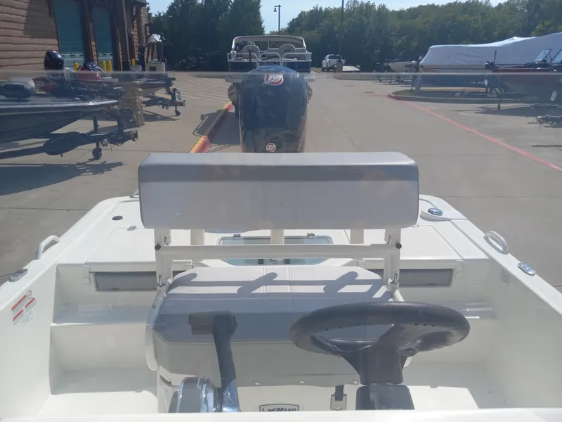 Slide: The Image of 2024 Mako Pro Skiff 19 CC boat interior with steering wheel and seating. - 5