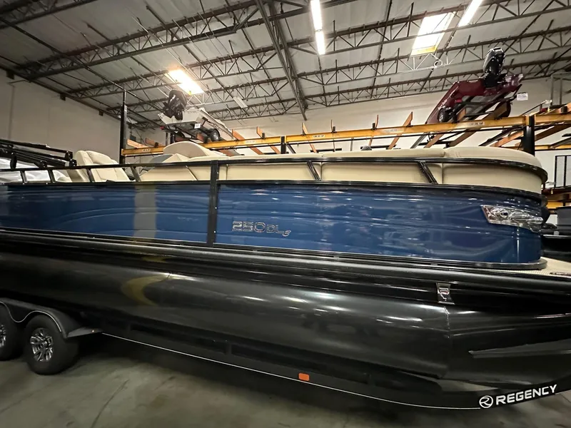 Slide: The Image of 2024 Regency 250 DL3 pontoon boat in warehouse, side view. - 0