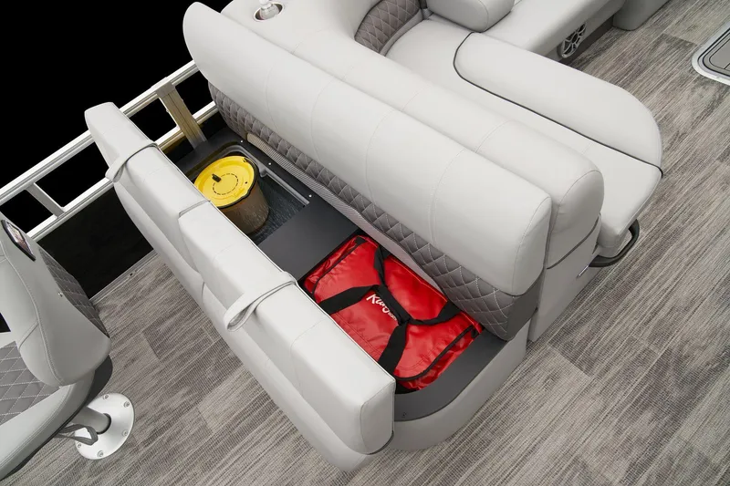 Slide: The Image of 2024 Ranger Reata 223F boat interior storage compartment with red life jacket and yellow bucket. - 49