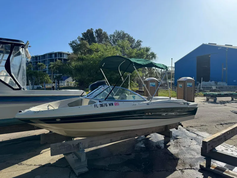 Slide: The Image of 2005 Sea Ray 180 Sport boat docked on a trailer in a marina. - 10