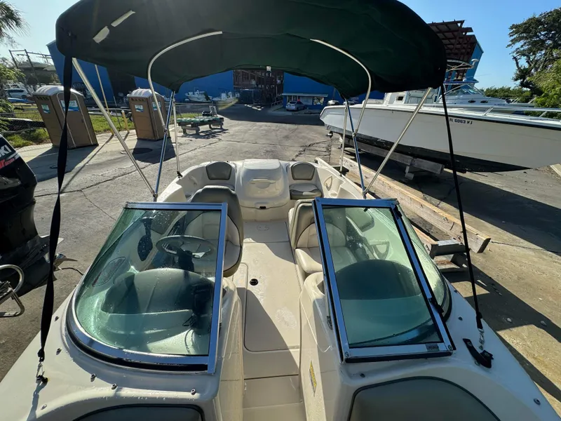 Slide: The Image of 2005 Sea Ray 180 Sport boat with green canopy, docked at marina. - 22