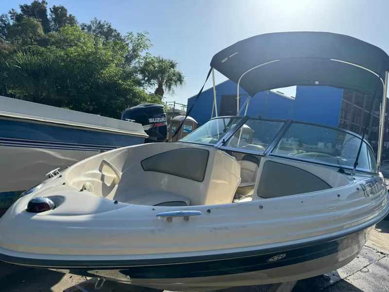 Slide: The Image of 2005 Sea Ray 180 Sport boat with canopy in marina under sunlight. - 26