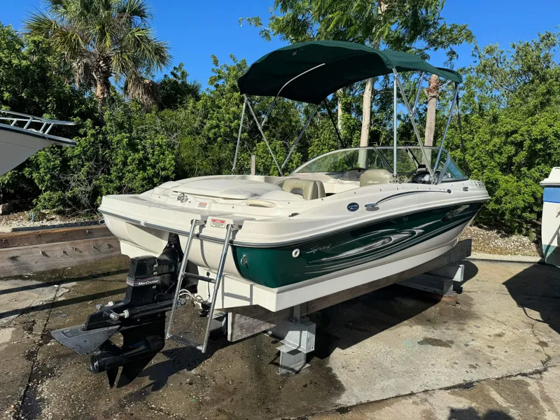 Slide: The Image of 2005 Sea Ray 180 Sport boat on a lift with green canopy. - 32