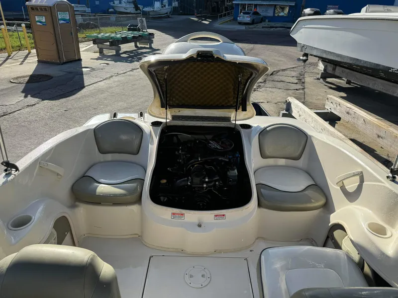 Slide: The Image of 2005 Sea Ray 180 Sport boat interior with open engine compartment at a marina. - 33