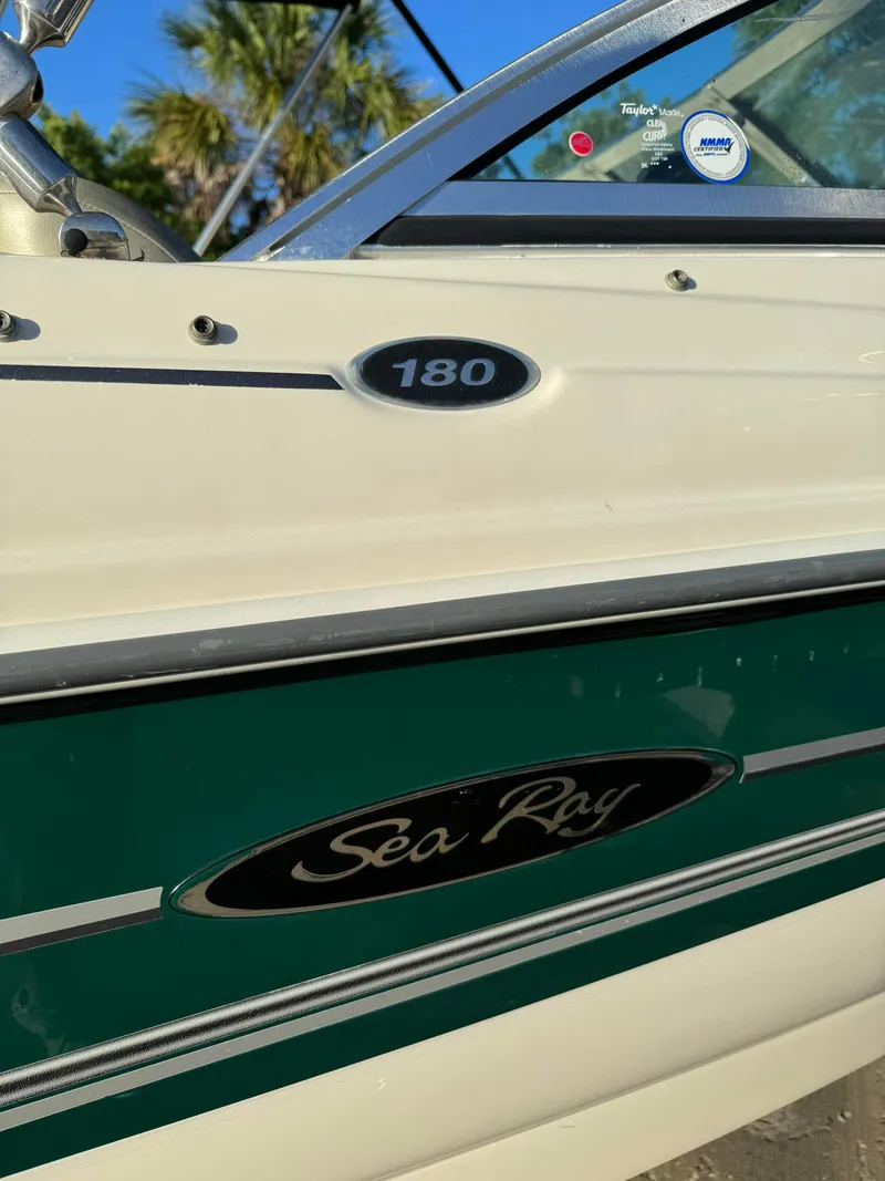 Slide: The Image of Close-up of a 2005 Sea Ray 180 Sport boat with green and white detailing. - 9