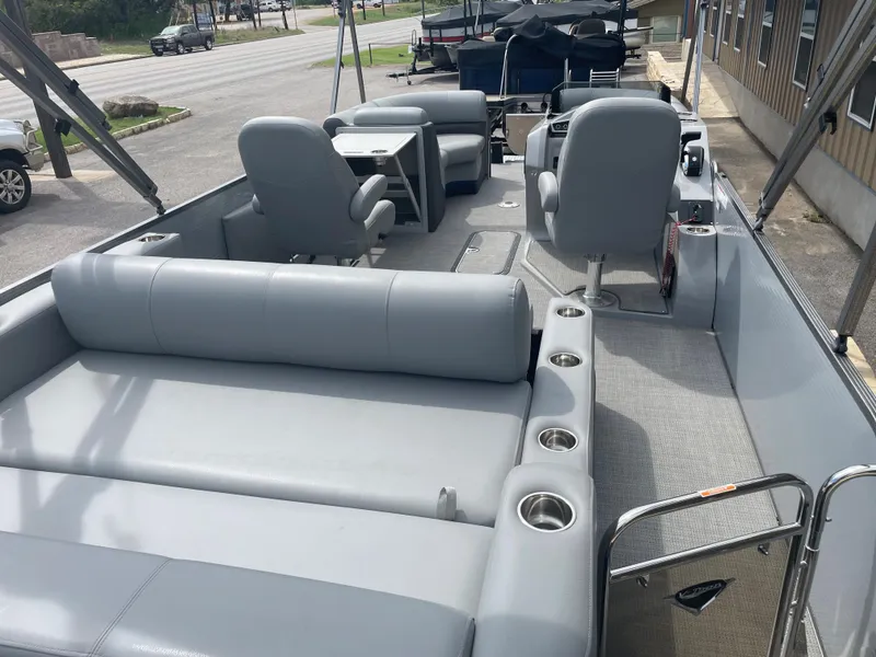 Slide: The Image of 2022 Manitou Oasis 23 SL SHP373 pontoon boat interior with gray seating and cup holders. - 6