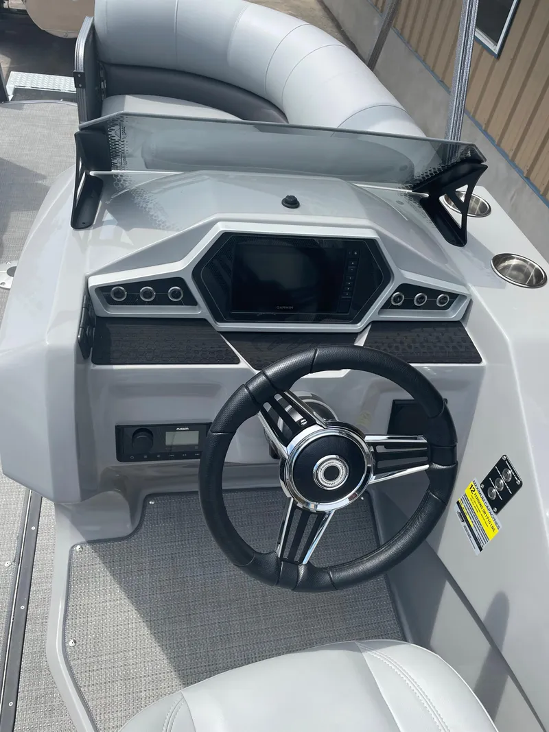 Slide: The Image of 2022 Manitou Oasis 23 SL SHP373 boat dashboard with steering wheel and control panel. - 7