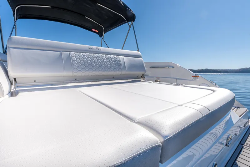 Slide: The Image of 2021 Sea Ray SDX 250 boat with sunpad, black canopy, and scenic water view. - 10