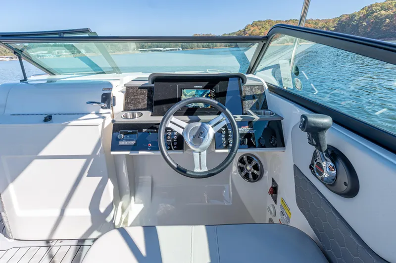 Slide: The Image of 2021 Sea Ray SDX 250 boat cockpit with steering wheel and dashboard on a sunny day. - 19