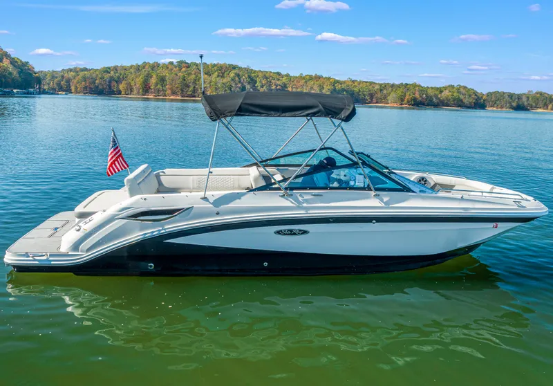 Slide: The Image of 2021 Sea Ray SDX 250 boat on a serene lake with clear skies. - 3