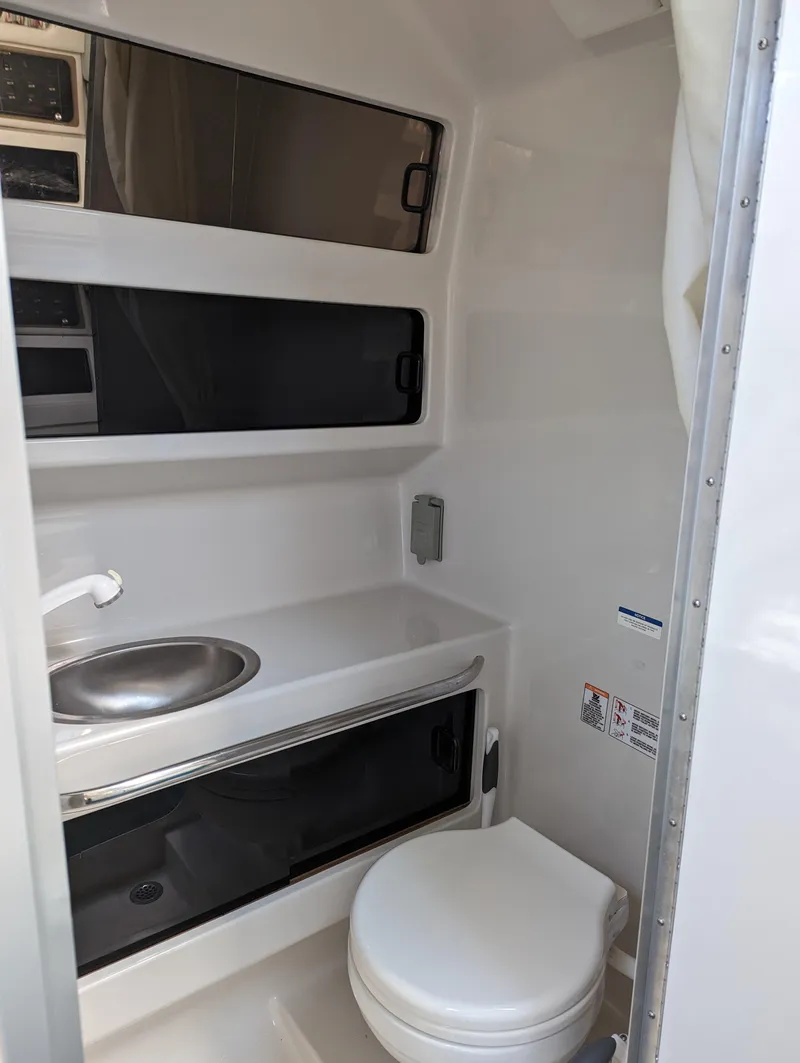 Slide: The Image of Compact bathroom in 1993 Chaparral 280 Signature boat with sink and toilet. - 7