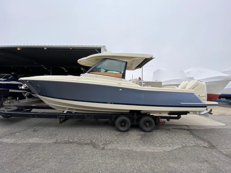 The Image of 2024 Chris-Craft Calypso 32 boat on a trailer in a marina. - 0