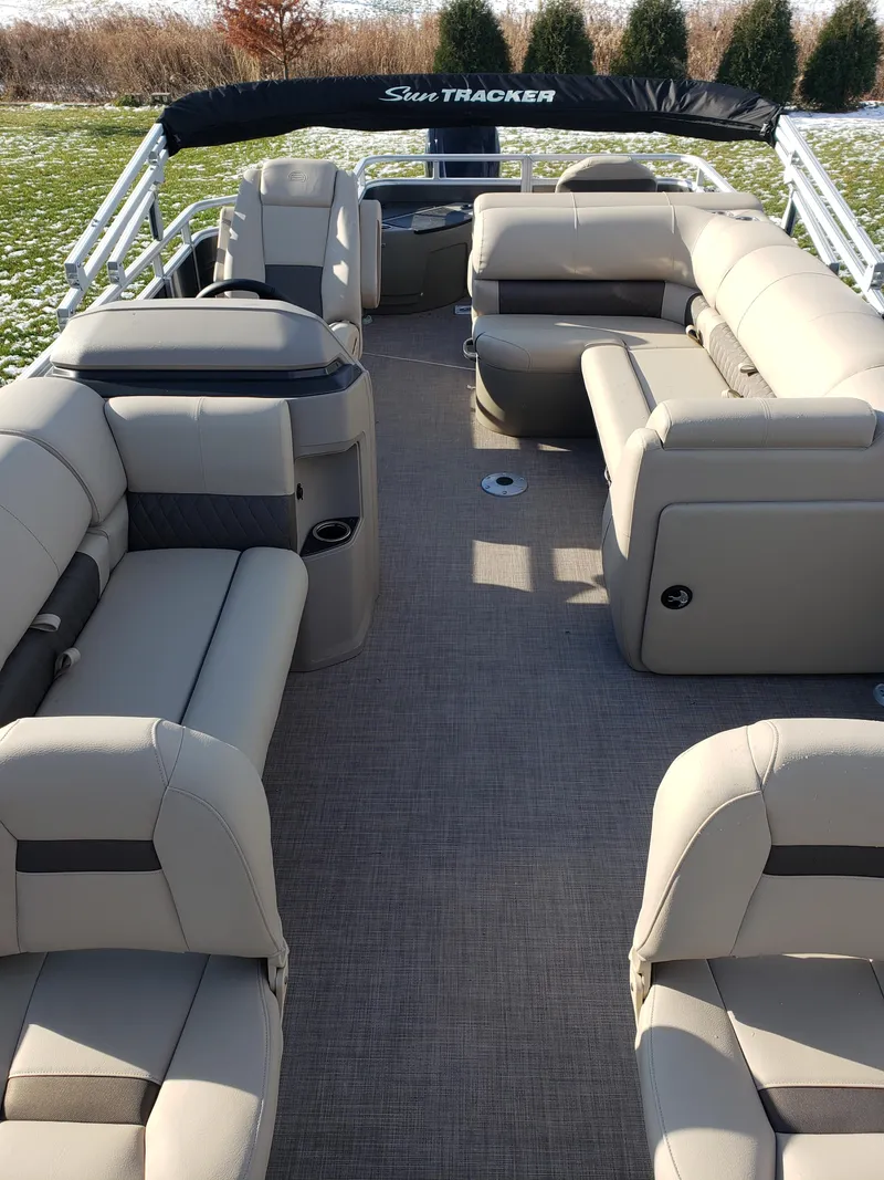 Slide: The Image of 2024 Sun Tracker Fishin' Barge 20 DLX interior with beige seating. - 3