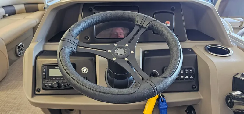 Slide: The Image of 2024 Sun Tracker Party Barge 20 DLX steering console with controls and cup holder. - 10