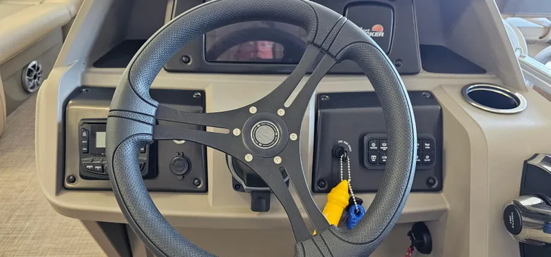 Slide: The Image of 2024 Sun Tracker Party Barge 20 DLX steering wheel and dashboard controls. - 13