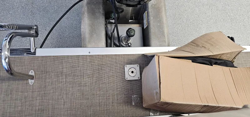 Slide: The Image of 2024 Sun Tracker Party Barge 20 DLX deck with cardboard box and railing. - 17