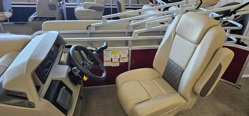 Slide: The Image of 2024 Sun Tracker Party Barge 20 DLX interior with beige captain's chair and steering console. - 8
