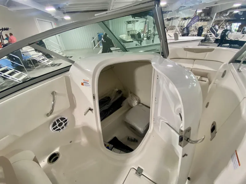 Slide: The Image of 2024 Robalo R207 Dual Console boat interior with storage compartment open. - 16