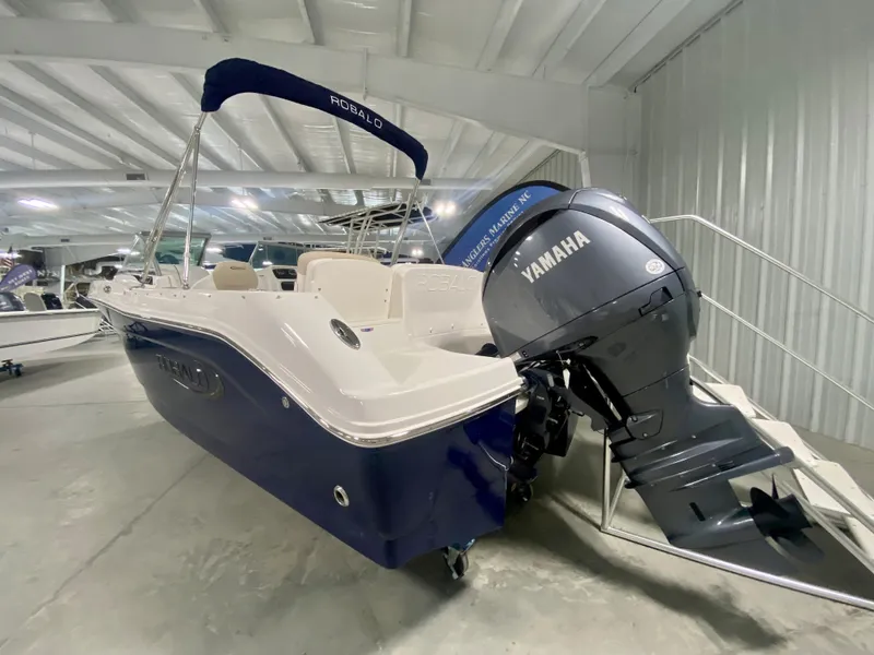 Slide: The Image of 2024 Robalo R207 Dual Console boat with Yamaha outboard motor in showroom. - 2