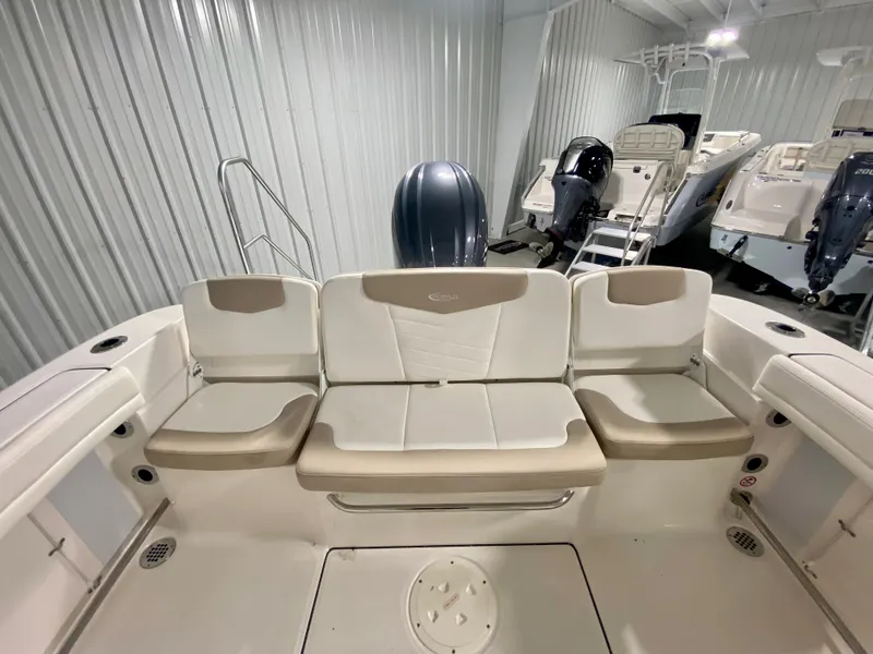 Slide: The Image of 2024 Robalo R207 Dual Console boat interior with cushioned seating and outboard motor. - 6