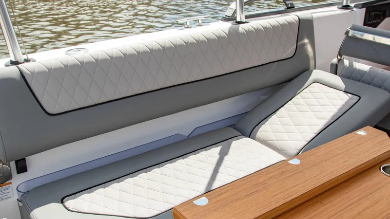 Slide: The Image of 2023 Alfastreet 23 Cabin Electric boat interior with quilted seating and wooden table. - 44
