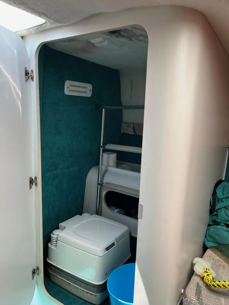 Slide: The Image of 1993 Chris-Craft 238 Concept boat interior bathroom with portable toilet and storage shelves. - 10