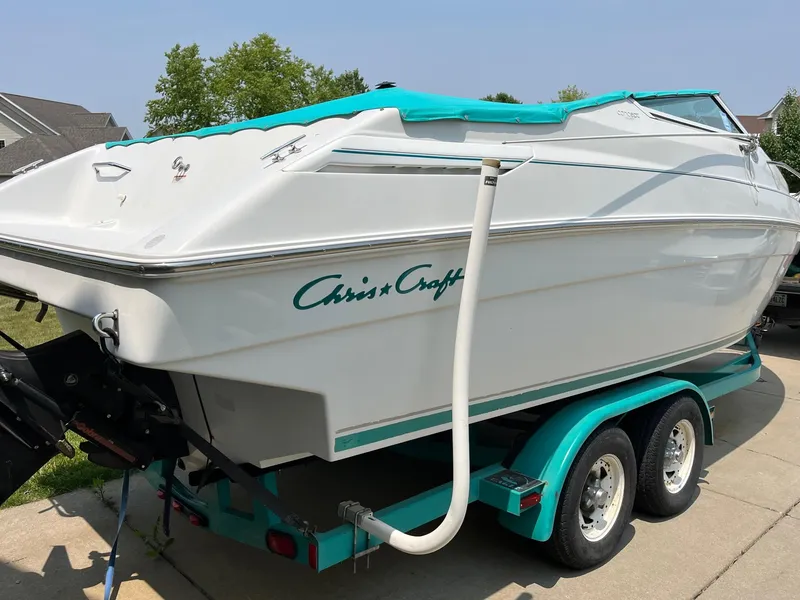 Slide: The Image of 1993 Chris-Craft 238 Concept boat on a trailer in a driveway. - 24