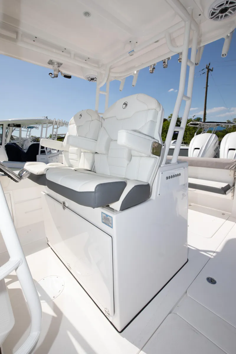 Slide: The Image of 2024 Edgewater 340CC boat interior with white cushioned seating. - 10