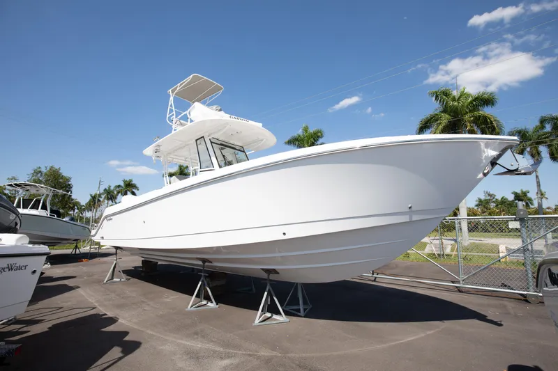 Slide: The Image of 2024 Edgewater 340CC boat on display in a marina under a clear blue sky. - 22