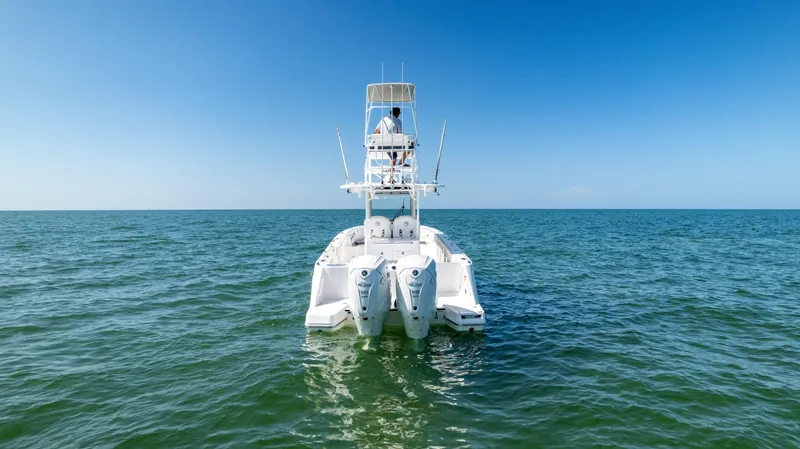 Slide: The Image of 2024 Edgewater 340CC boat on open sea, rear view, clear blue sky. - 3