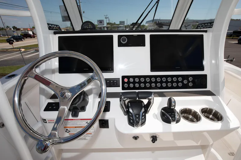 Slide: The Image of 2024 Edgewater 340CC boat helm with dual screens and controls. - 34